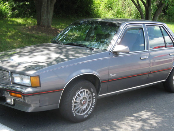 a slate gray cadillac cimarron with a red trim line