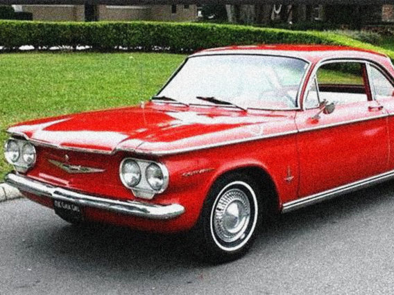 a red chevrolet corvair with the driver side window rolled down
