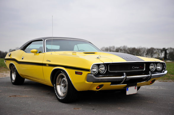 a yellow dodge challenger with a black racing stripe down the side of the vehicle