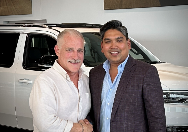 Tim Wild, left, director of the Midwest and Plains Region for Tim Lamb Group, and Penuel “Raj” Clement after Clement closed on the purchase of Marty Cancila Dodge Chrysler Jeep Ram - Clement Auto...