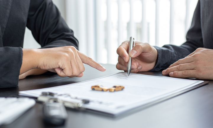 Two people signing auto insurance paperwork