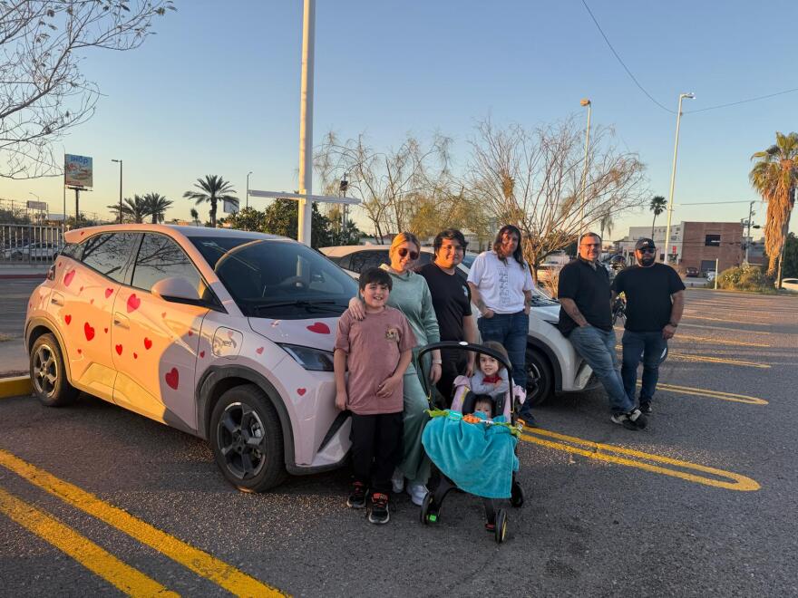 BYD Dolphin Mini owners gather in a parking lot one evening. Most of the members of their group use the affordable, Chinese electric cars to drive for rideshare apps.